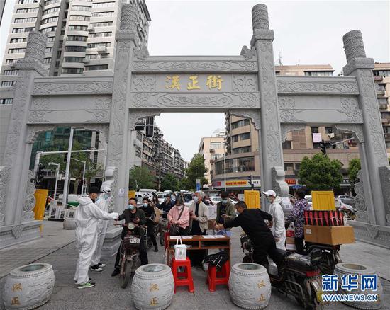  4月16日，進(jìn)出武漢漢正街步行街的人員在掃描健康碼。新華社記者 王毓國(guó) 攝